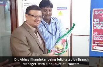 Dr. Abhay Khandekar being felicitated by Branch Manager with a Bouquet of Flowers 