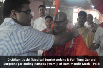 Dr. Nikunj Joshi (Medical Suprintendant & Full TIme General Surgeon) garlanding Ramdas Swamiji of Ram Mandir Math - Paldi